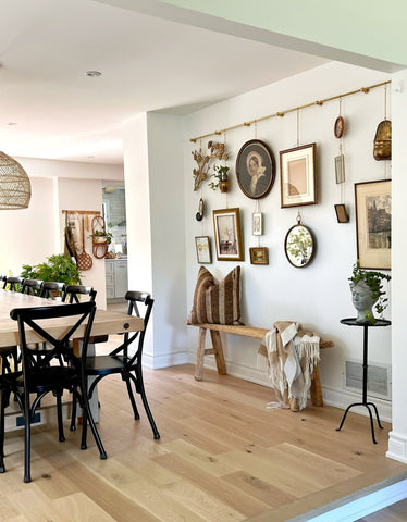 Una elegante pared de estilo moderno de galería con varios marcos colgados de un sistema de rieles.